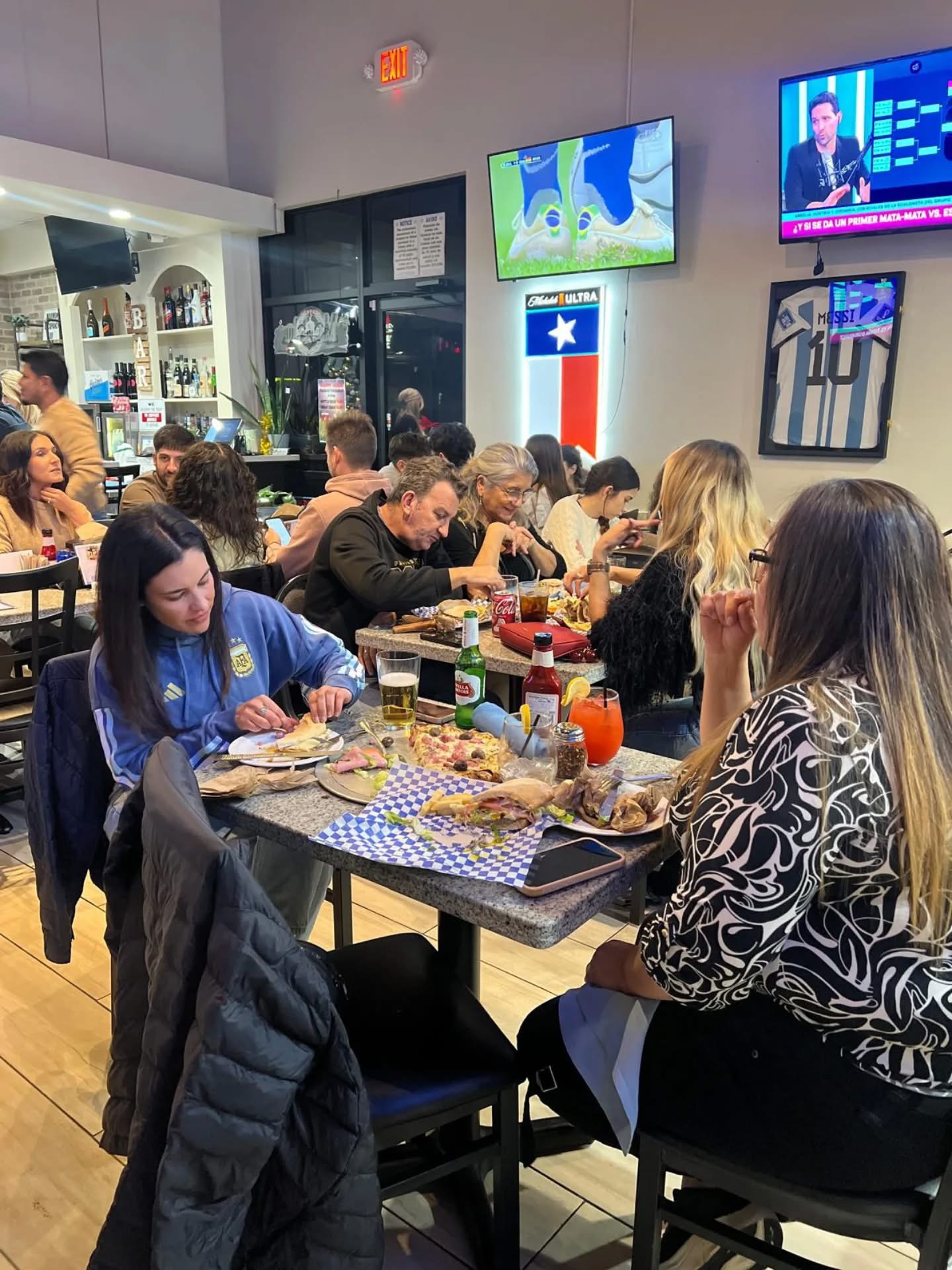 Mesa con pizza, milanesa y cervezas mientras juega Argentina en TV